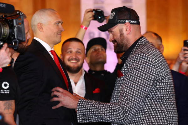 Para penggemar tinju terpukau saat Oleksandr Usyk tampil dengan gaya mencolok di konferensi pers menjelang rematch melawan Tyson Fury. Juara kelas berat ini mengenakan setelan jas dan sepatu hitam dengan dasi merah serta sarung tangan kulit